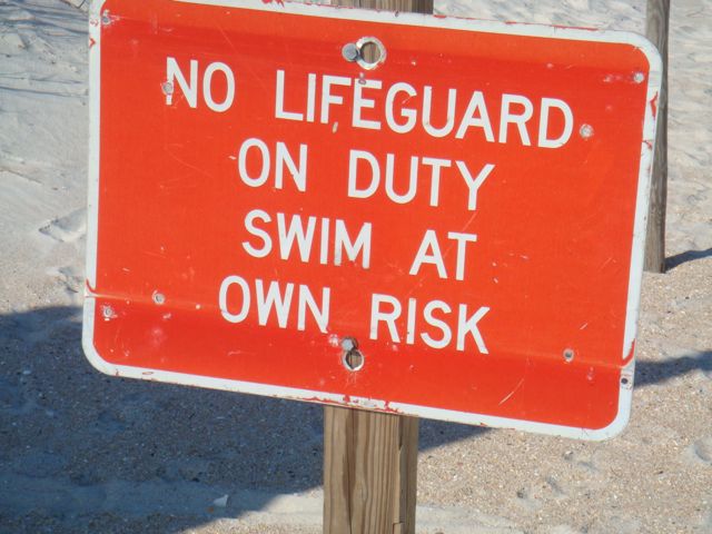 should say, no lifeguard, be sedentary at own risk photo of , No Lifeguard sign at Florida Beach