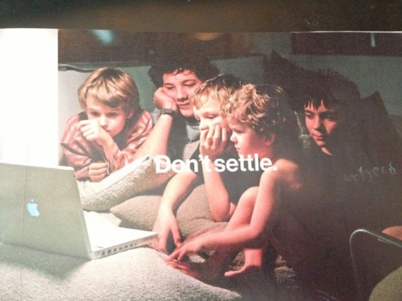 Children huddles around a Macbook