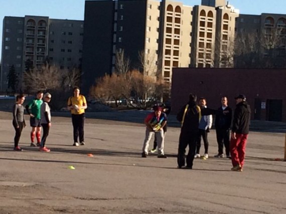 Middle aged adults conducting Rugby drills in Winnipeg parking lot