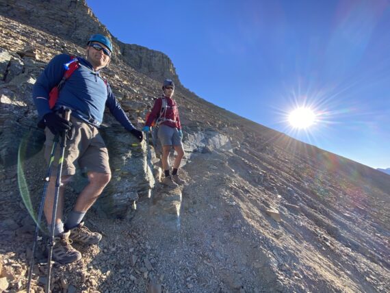 Two people on a steep mountain trail