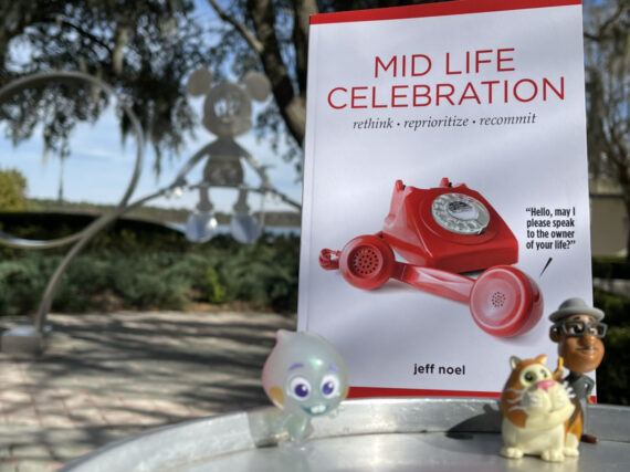 The book Mid Life Celebration with a couple of Pixar soul small toy characters