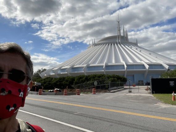 Man’s face with face mask and Space mountain in the background