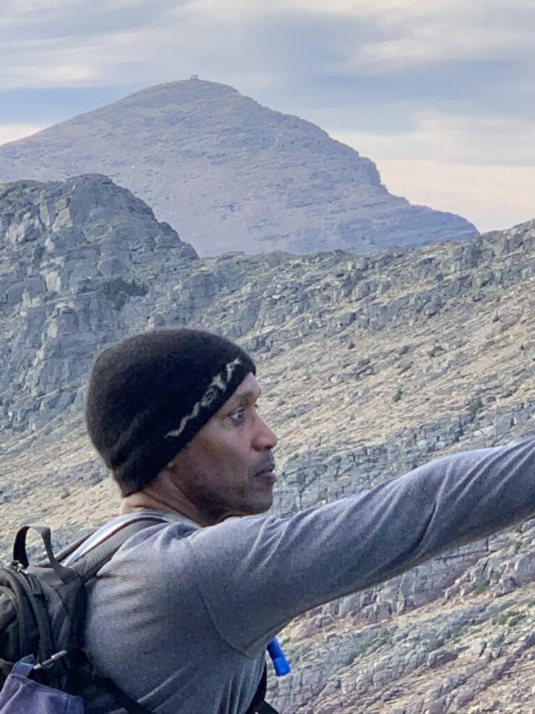 man pointing to a mountain vista