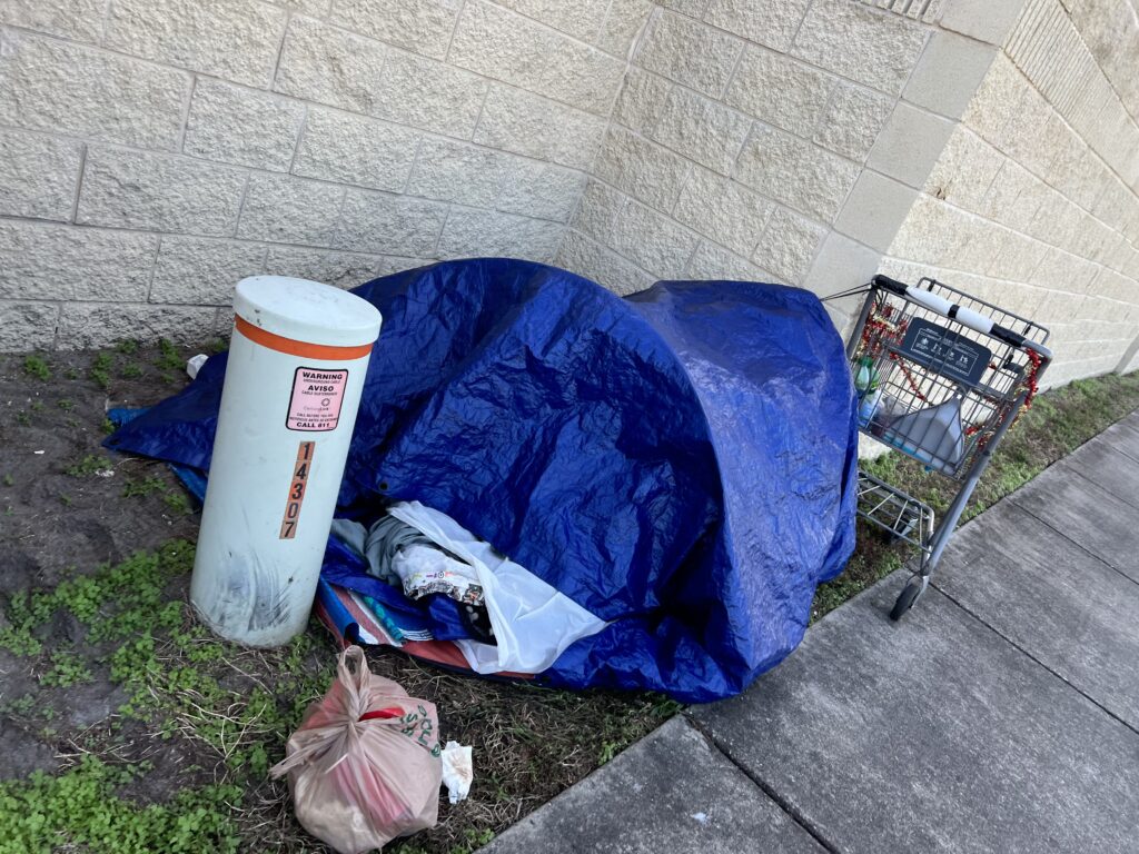 homeless person sleeping area next to a wall