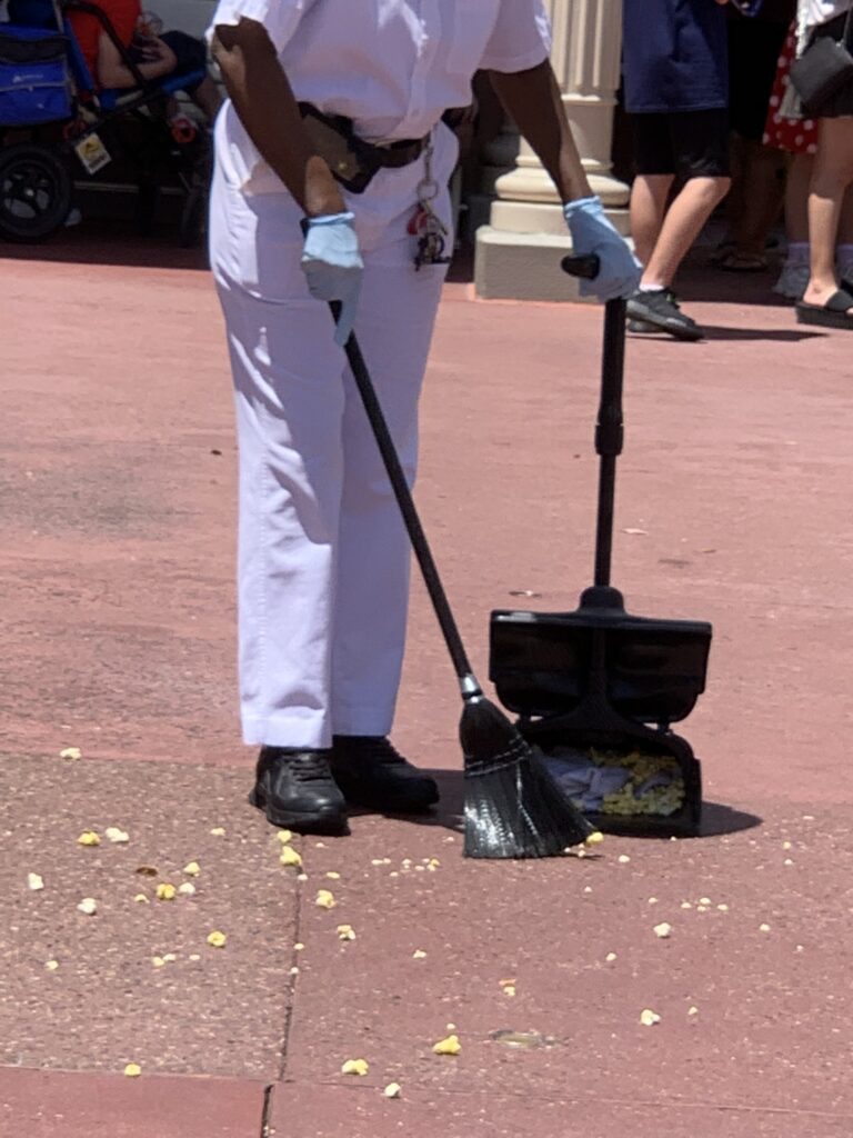 Disney Custodial Cast Member sweeping popcorn