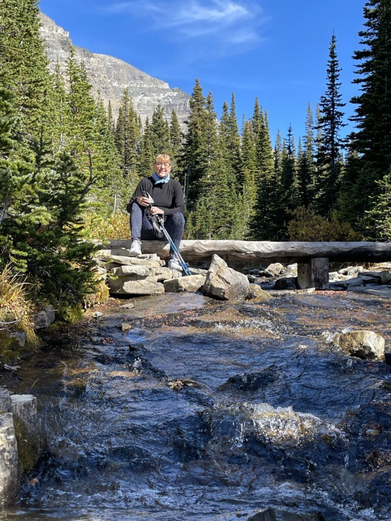woman sitting by mountain stream