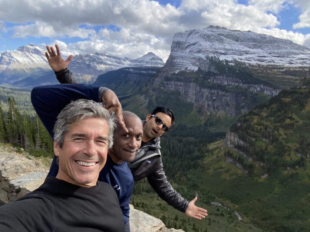 three men striking silly pose for mountain picture