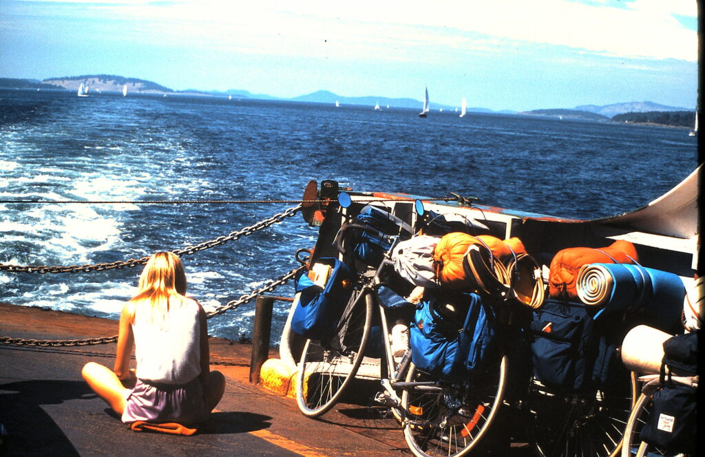 woman sitting on a ferry boat next to some bicycles