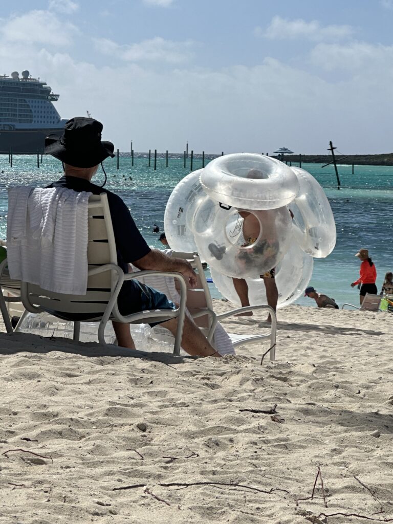 Man carrying six inner-tubes at beach